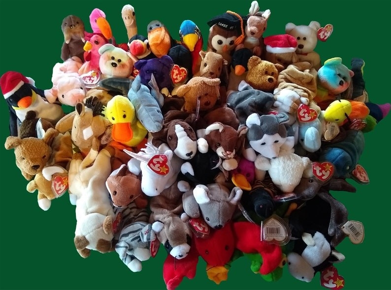 a pile of beanie babies on a green table top