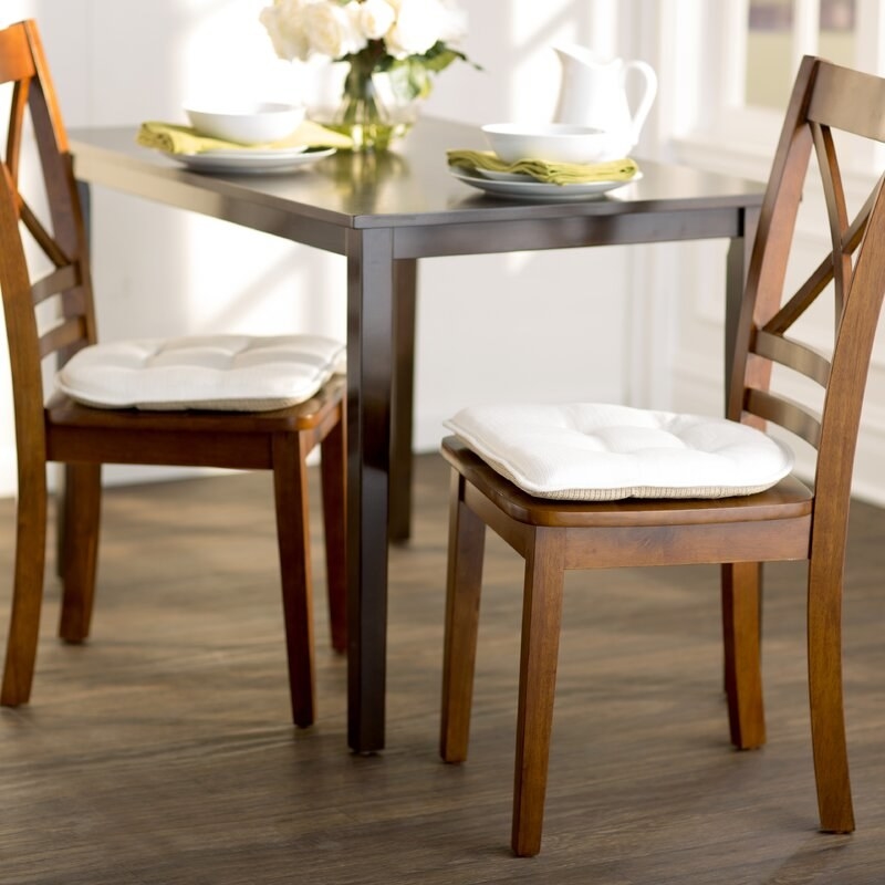 the two ivory seat cushions on wood chairs