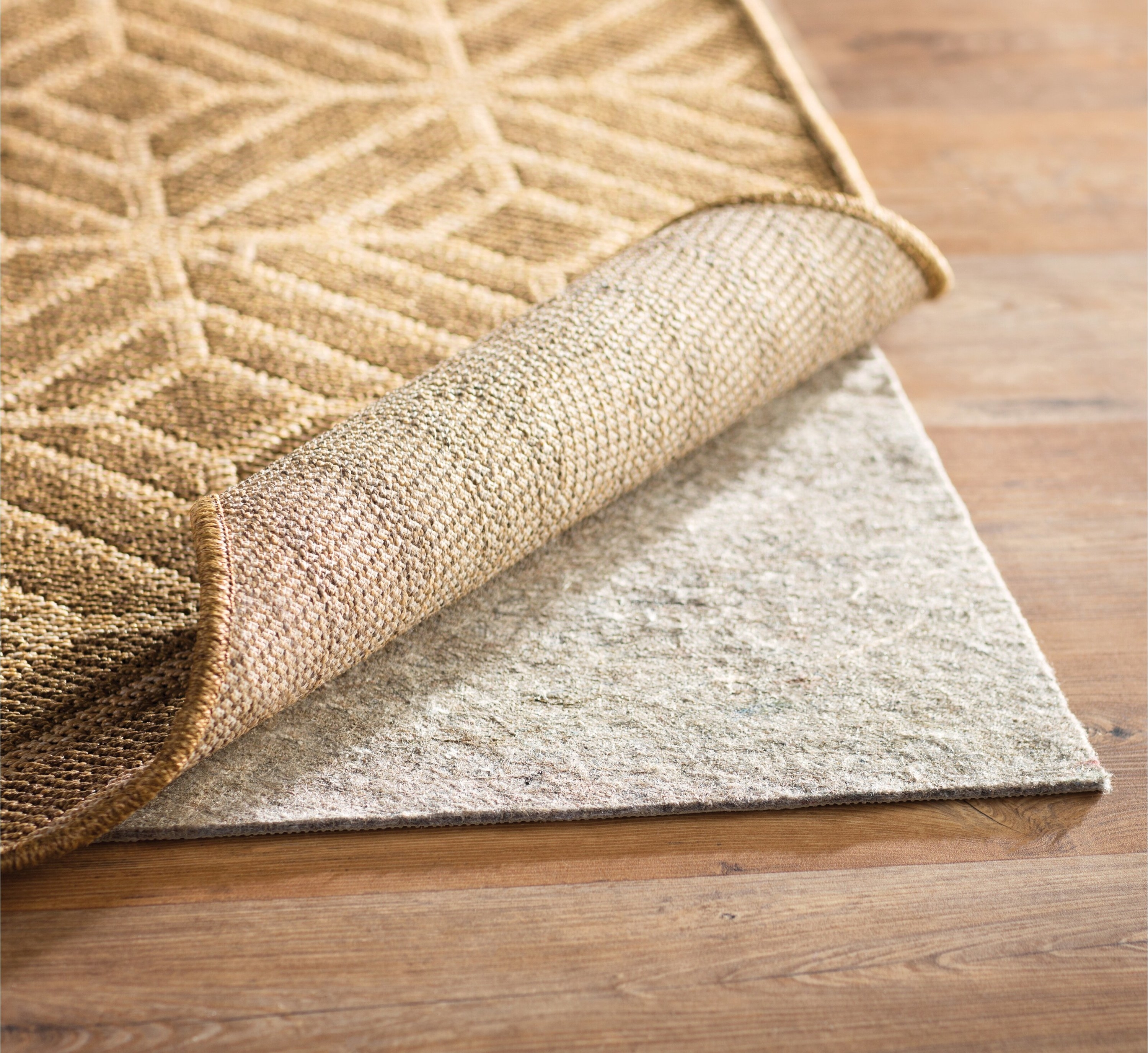 the rug mat under a tan rug