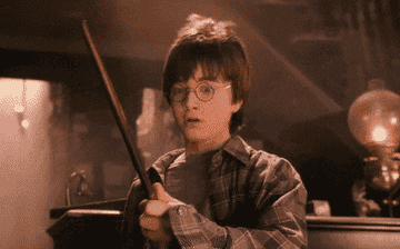gif of harry potter holding a wand and looking amazed