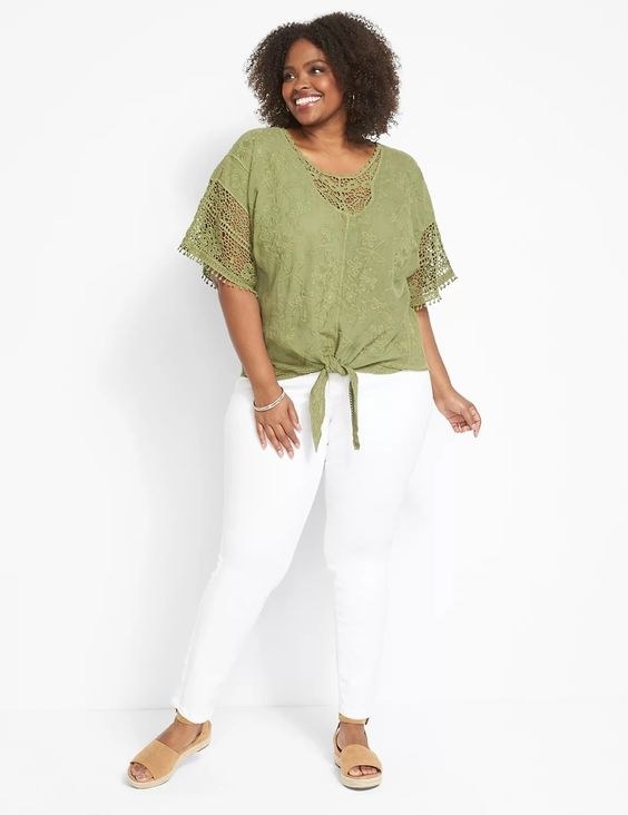Model in the green short sleeve top with white pants