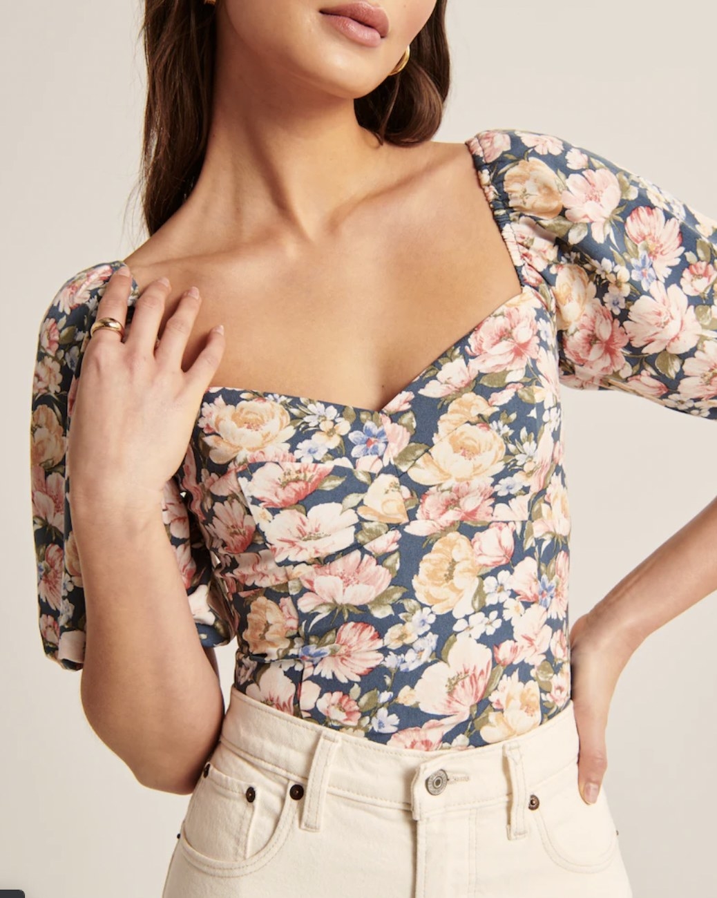 The floral corset top tucked into white jeans