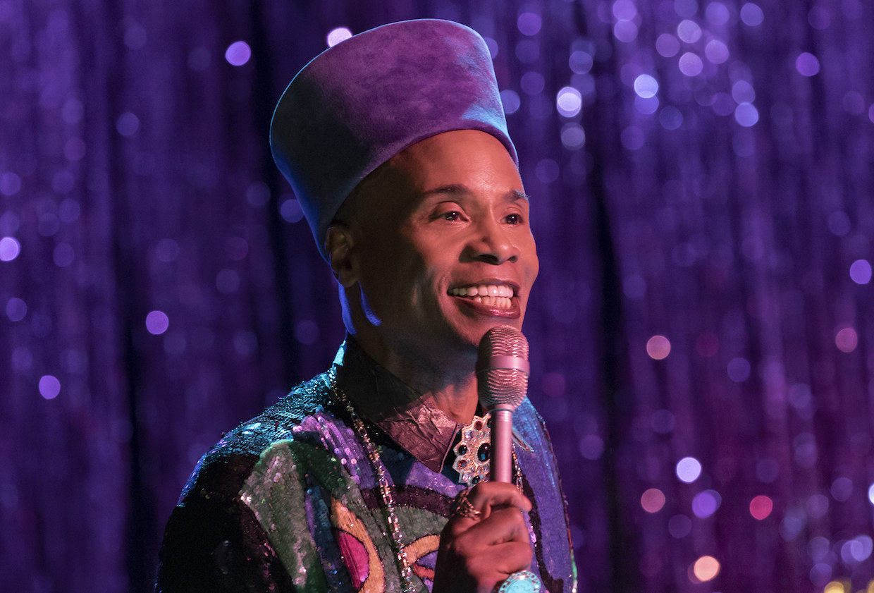 Billy Porter plays &quot;Pray Tell&quot; who has a mic in his hand smiling happily in Pose