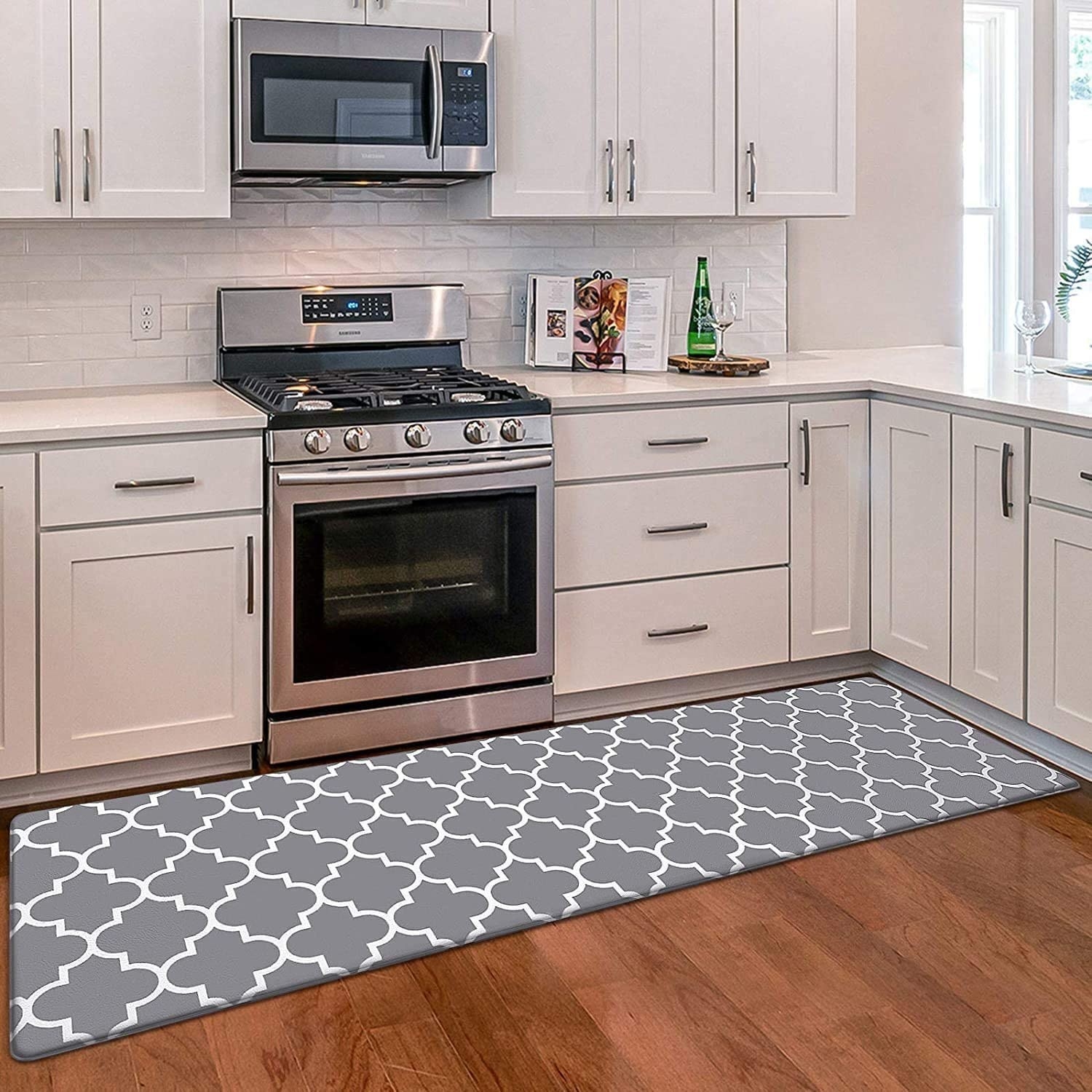 anti-fatigue gray and white patterned kitchen mat below white cabinets and stovetop