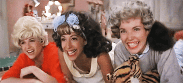 the pink ladies giggling at a sleepover in the movie grease