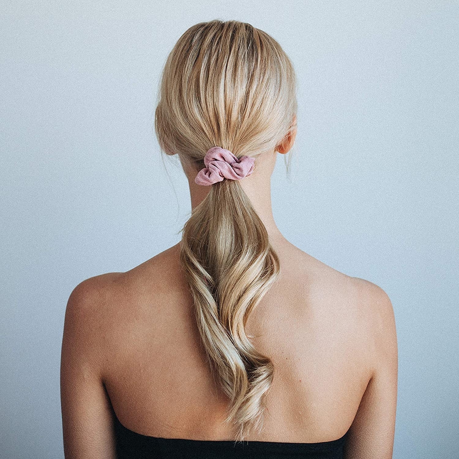 model with pink Kitsch scrunchie holding up blonde ponytail
