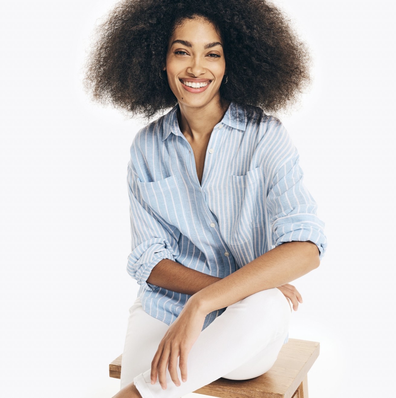 Model sitting in the blue and white striped button-down