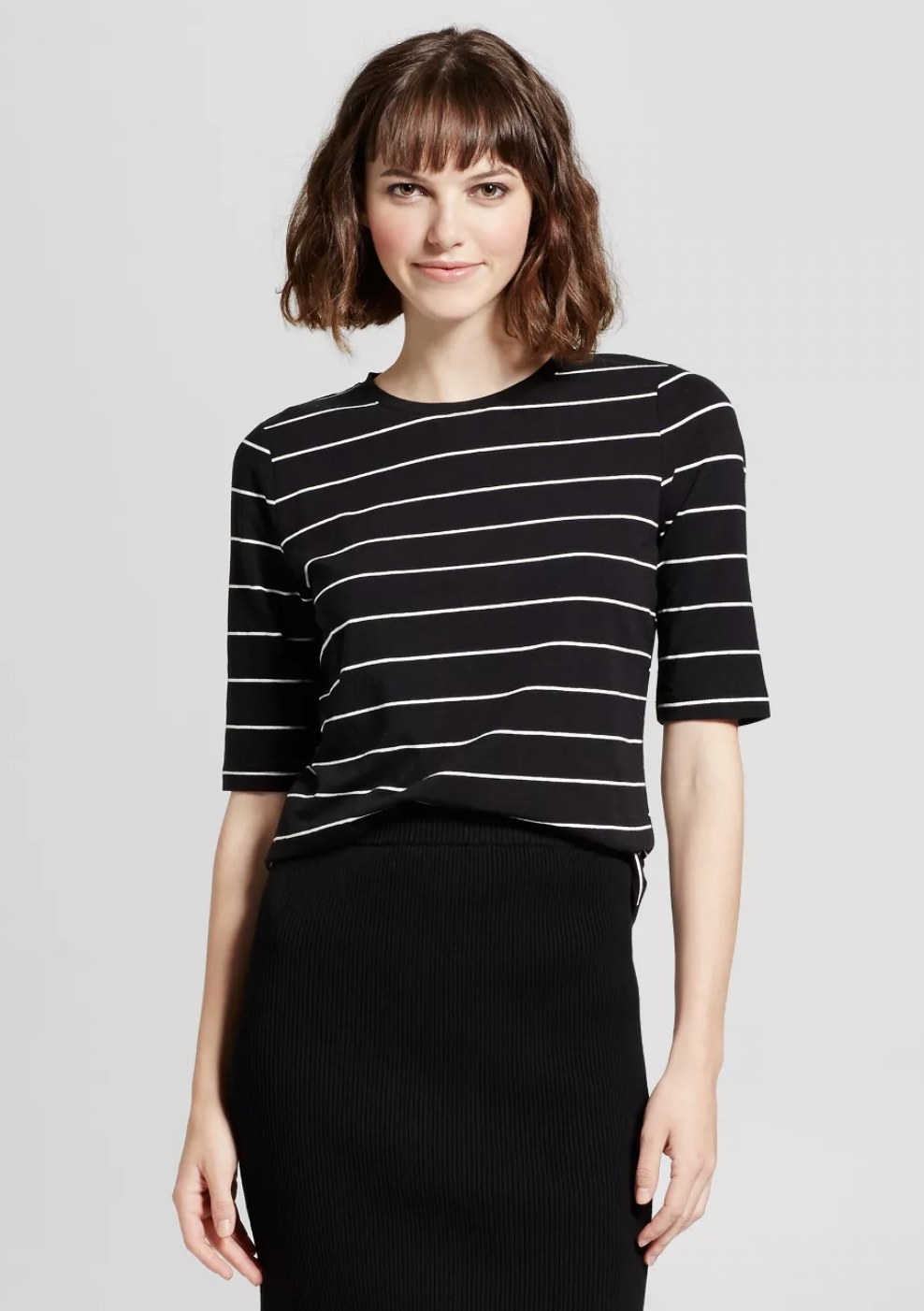 a person wearing the tee in black with thin, white stripes