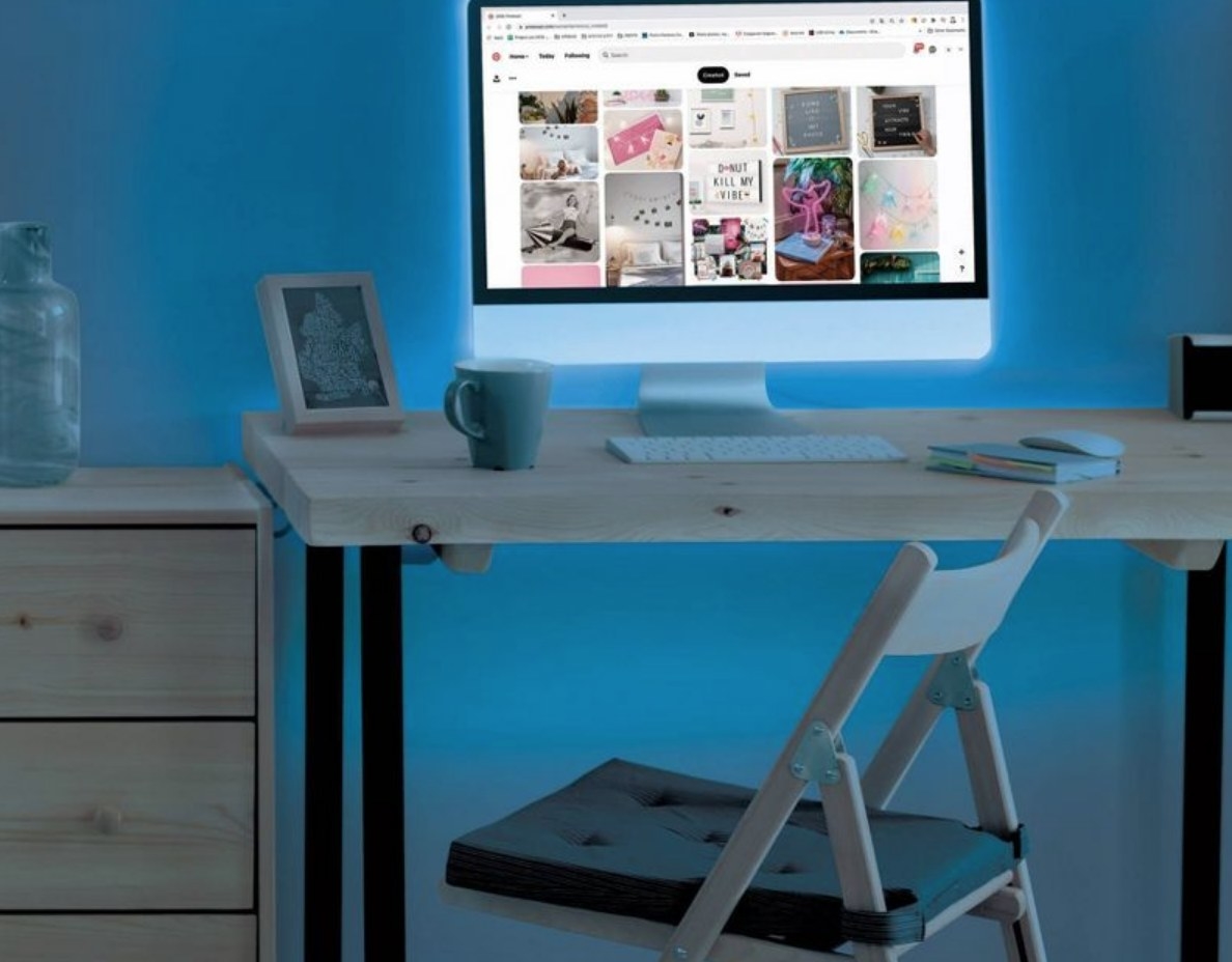 Blue LED light strip beind computer monitor on desk