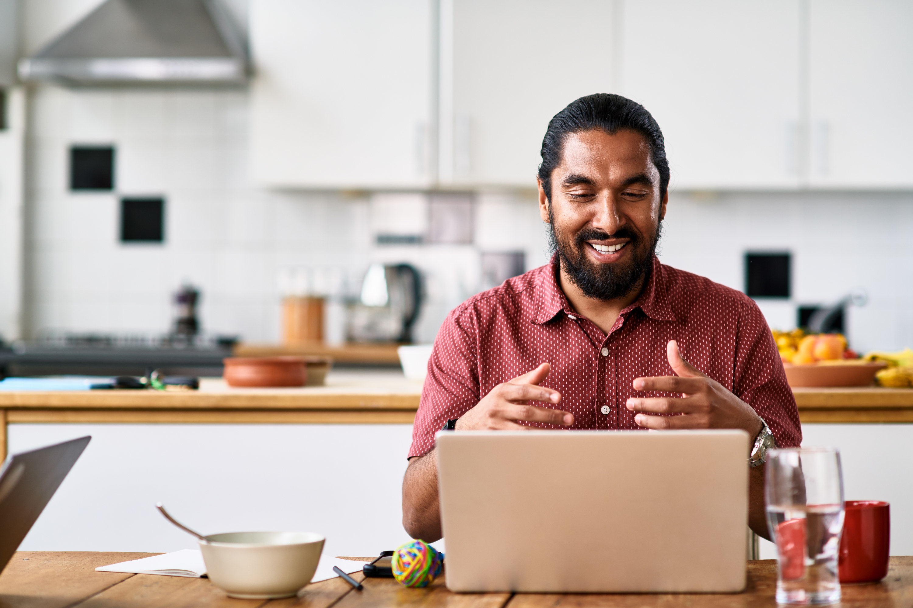 Man on his computer at the kitchen table