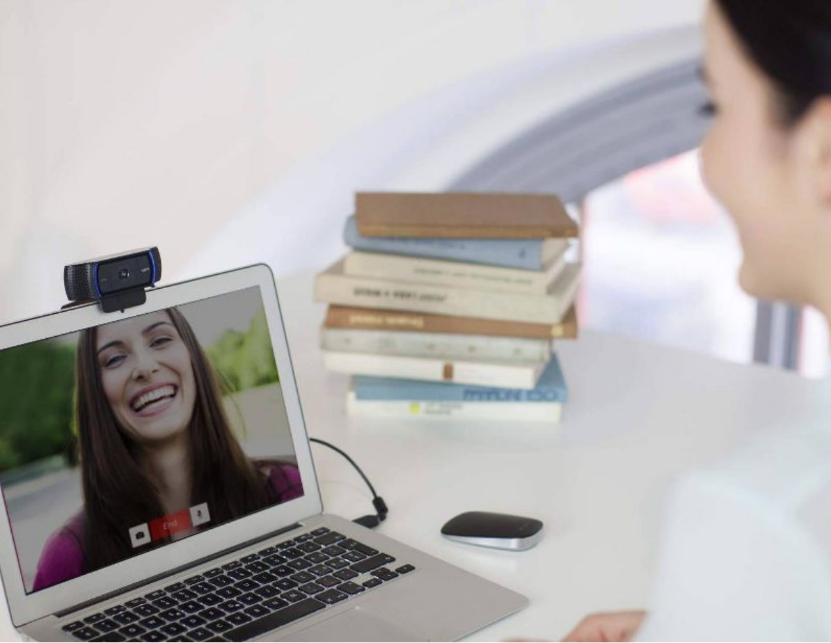 Model videochatting on laptop with attached HD webcam