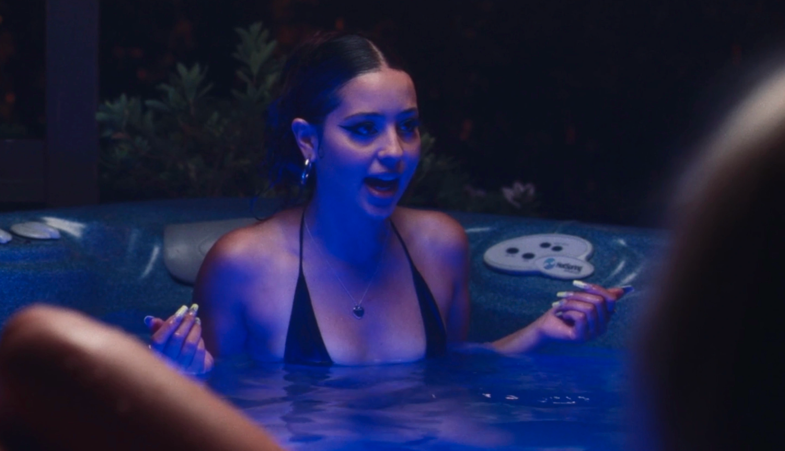 Maddy talking to friends in a hot tub