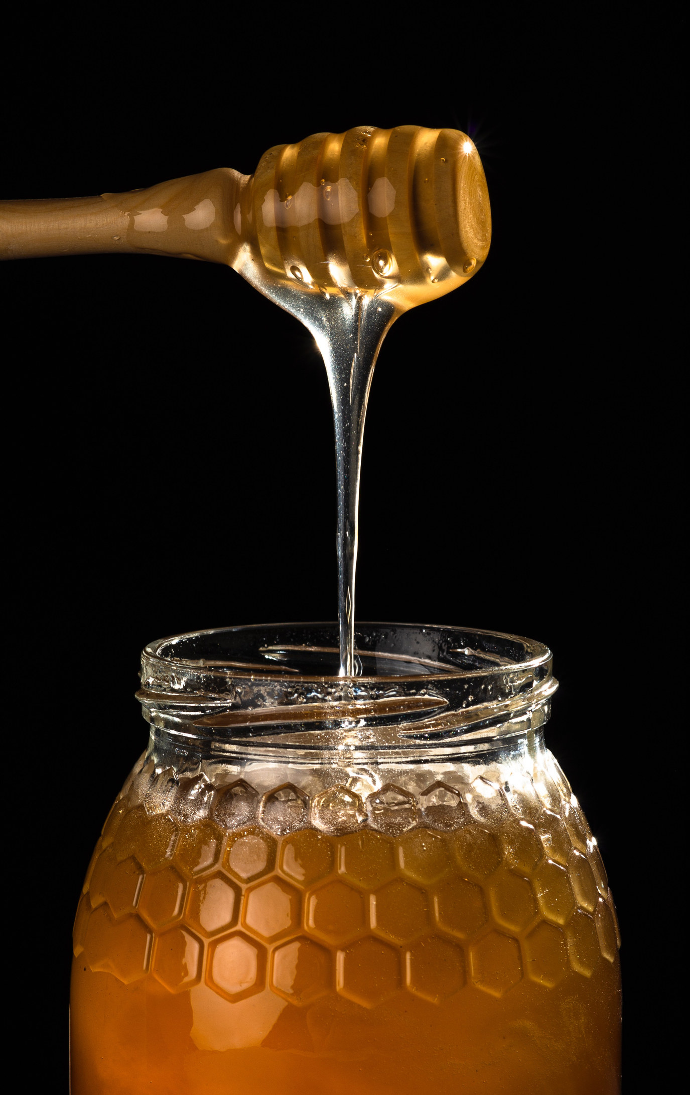 Honey being scooped from a jar