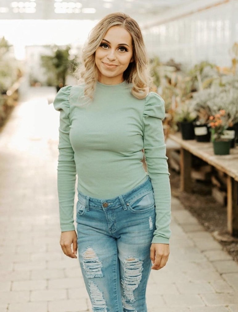 Reviewer's photo wearing the sea foam green top tucked into jeans