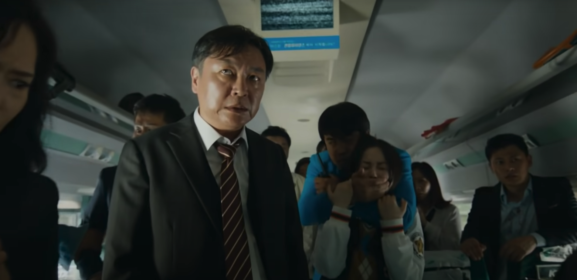 Kim Eui-sung as Yong-suk in a suit stares at survivors begging for help in &quot;Train to Busan&quot;