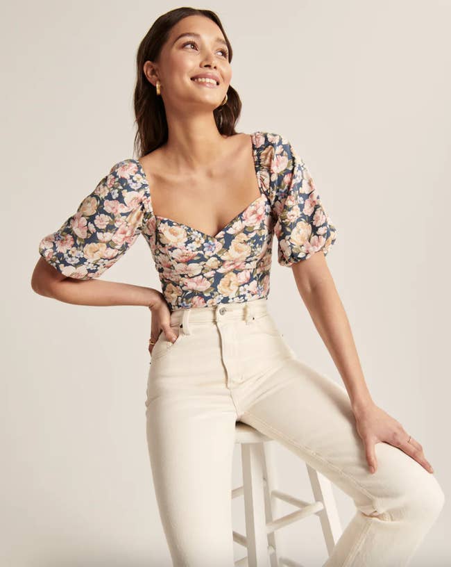 a model wearing the pink and navy floral top