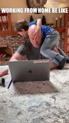 Child climbing on top of a man trying to work on his laptop