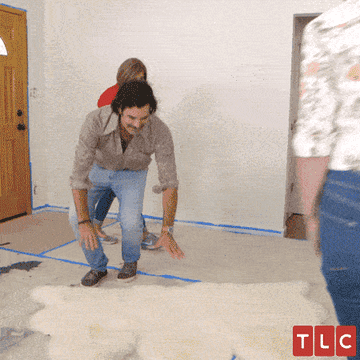 Actor on TLC&#x27;s show &quot;Trading Spaces&quot; laying down on a white rug