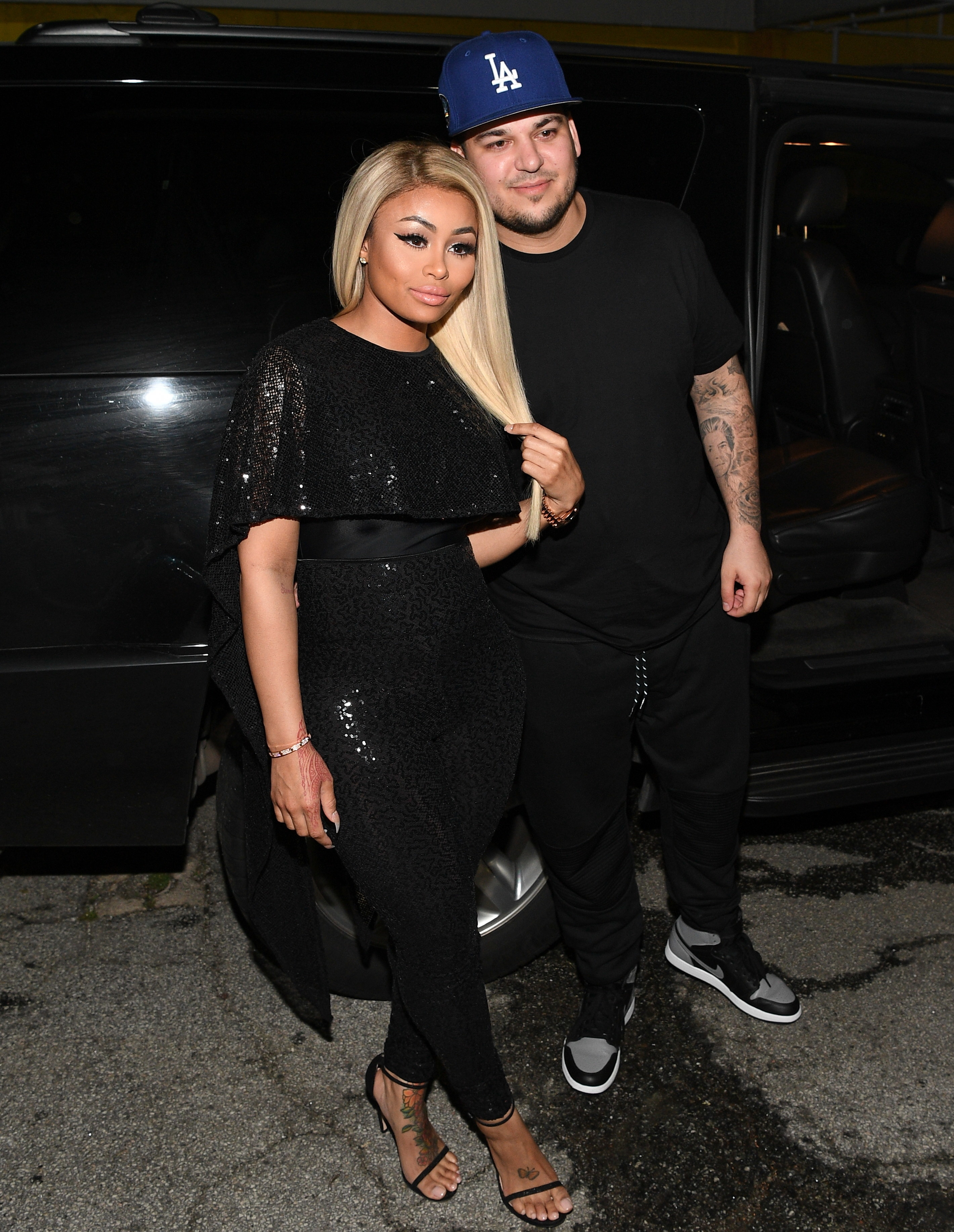 Blac Chyna and Rob Kardashian exiting a car and posing for paparazzi