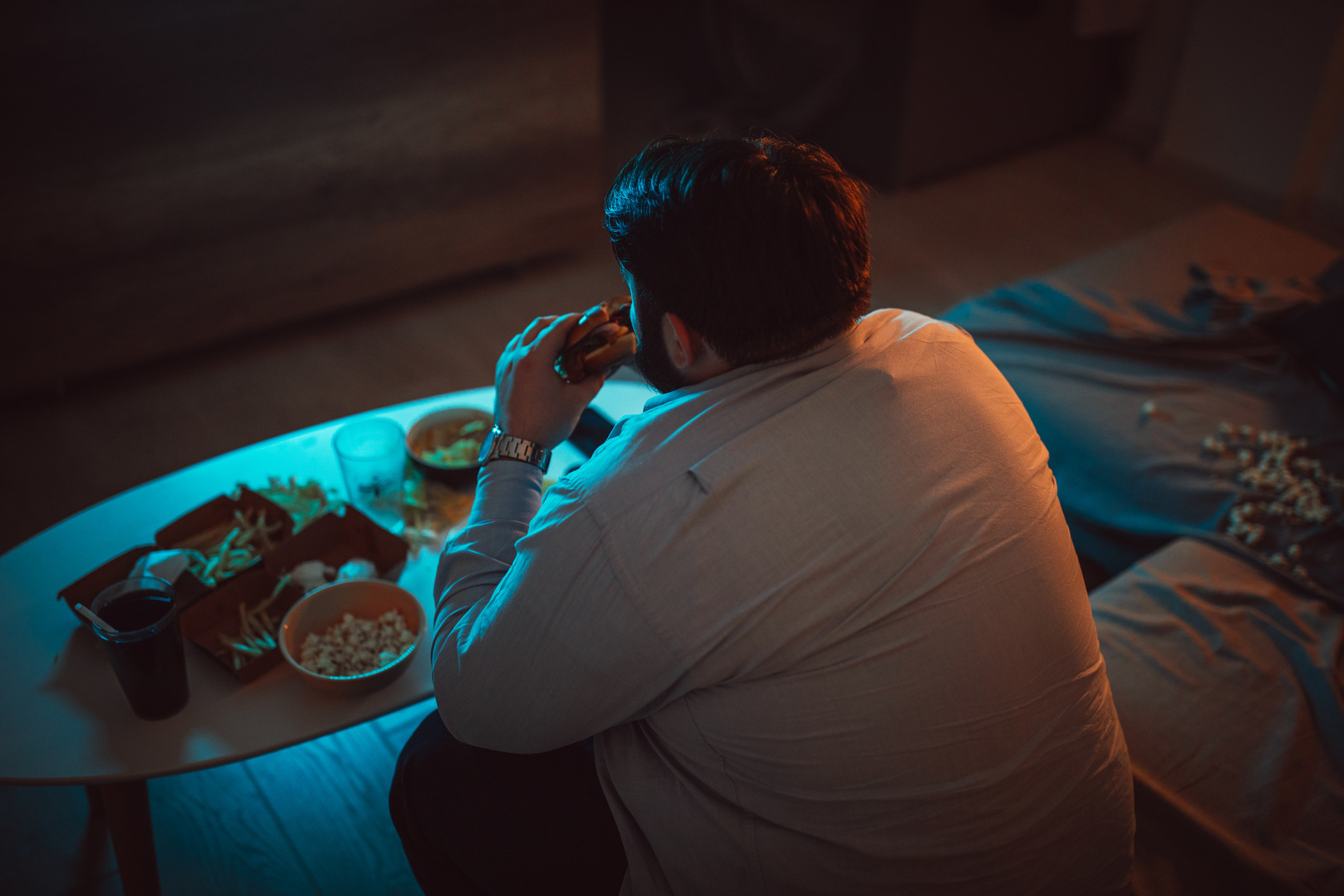 Man eating a full meal in front of the tv at night