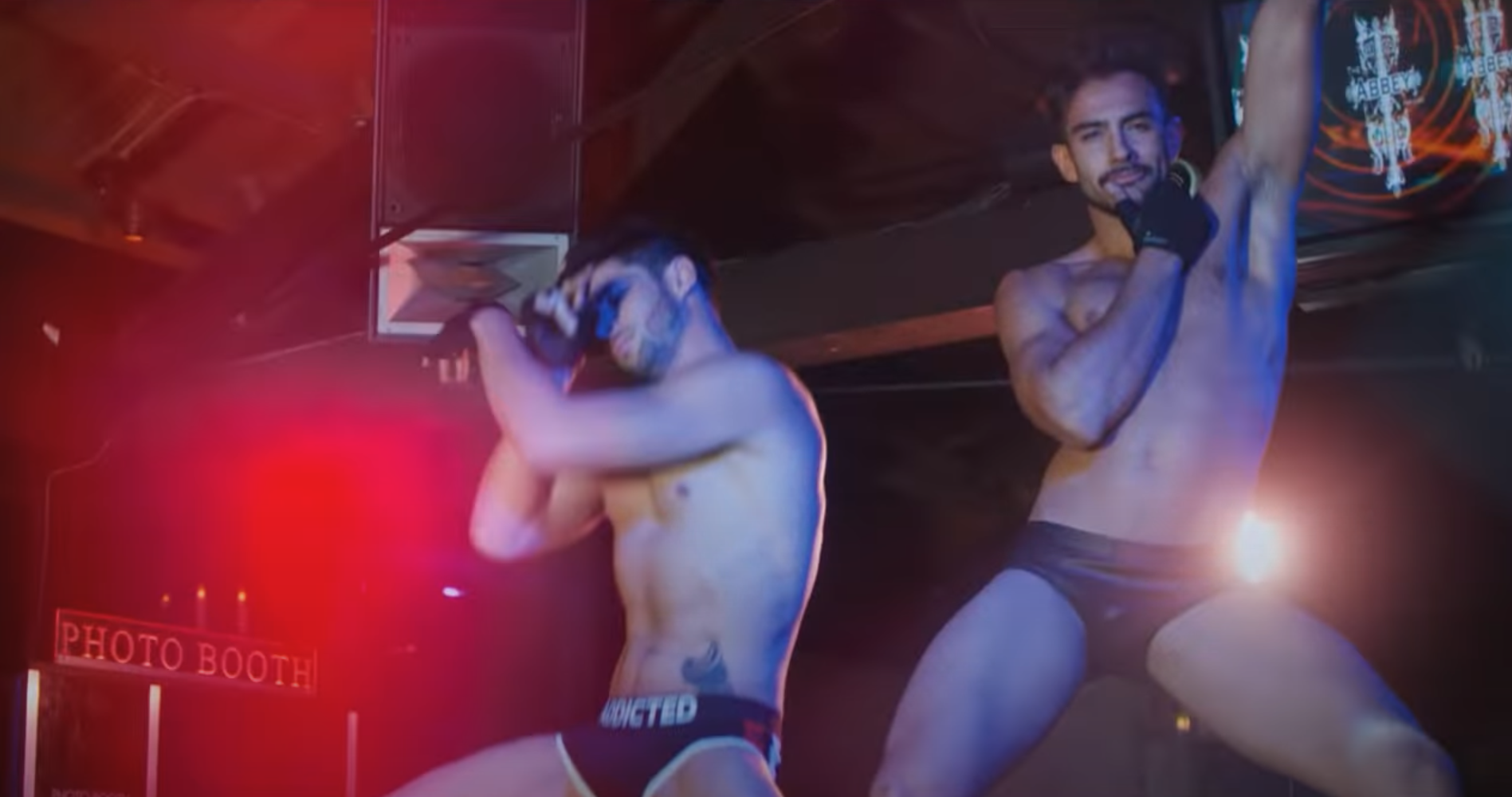 Two shirtless men dance as go-go boys at The Abbey club in West Hollywood, California