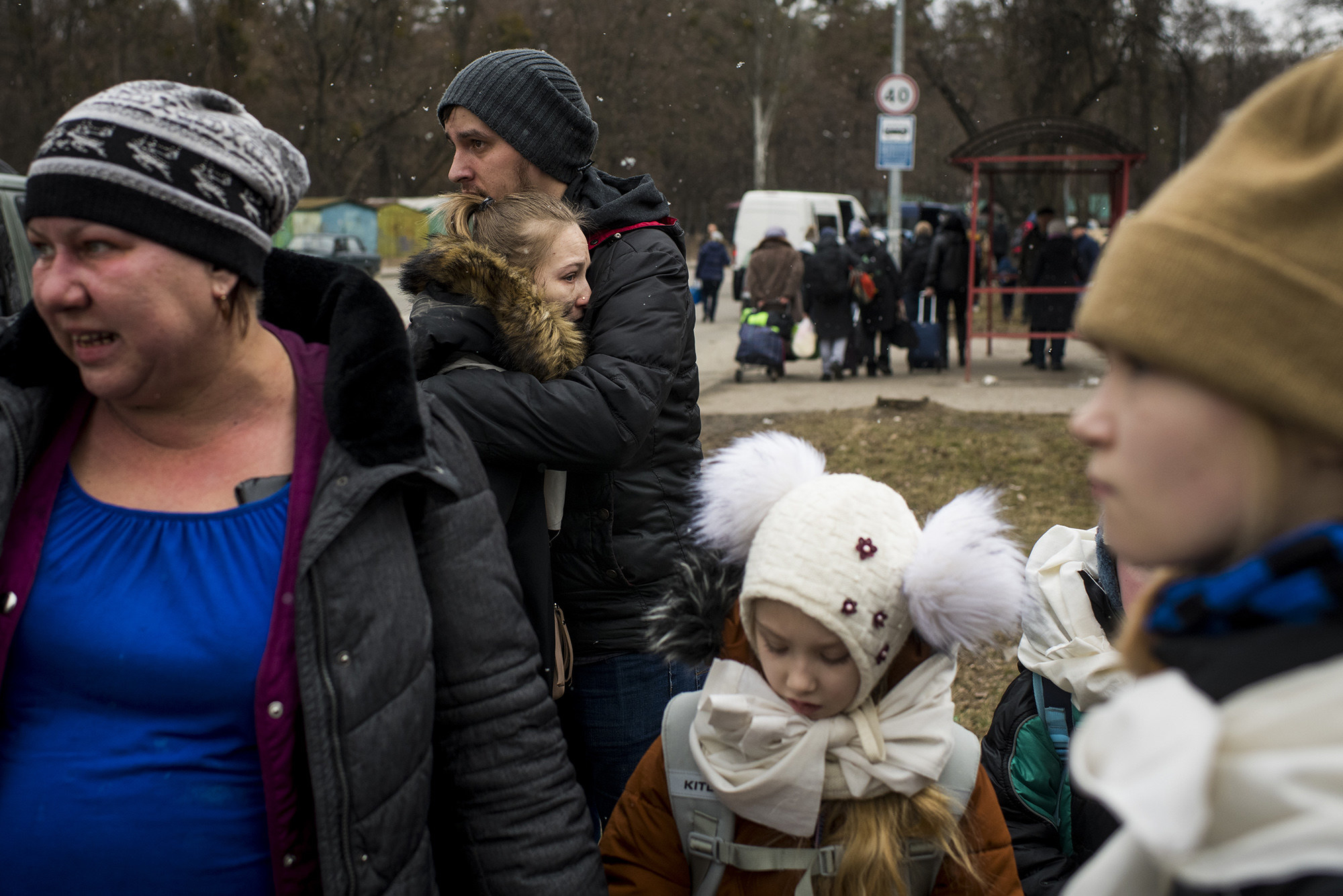 Women, a man, and children in heavy outerwear stand together