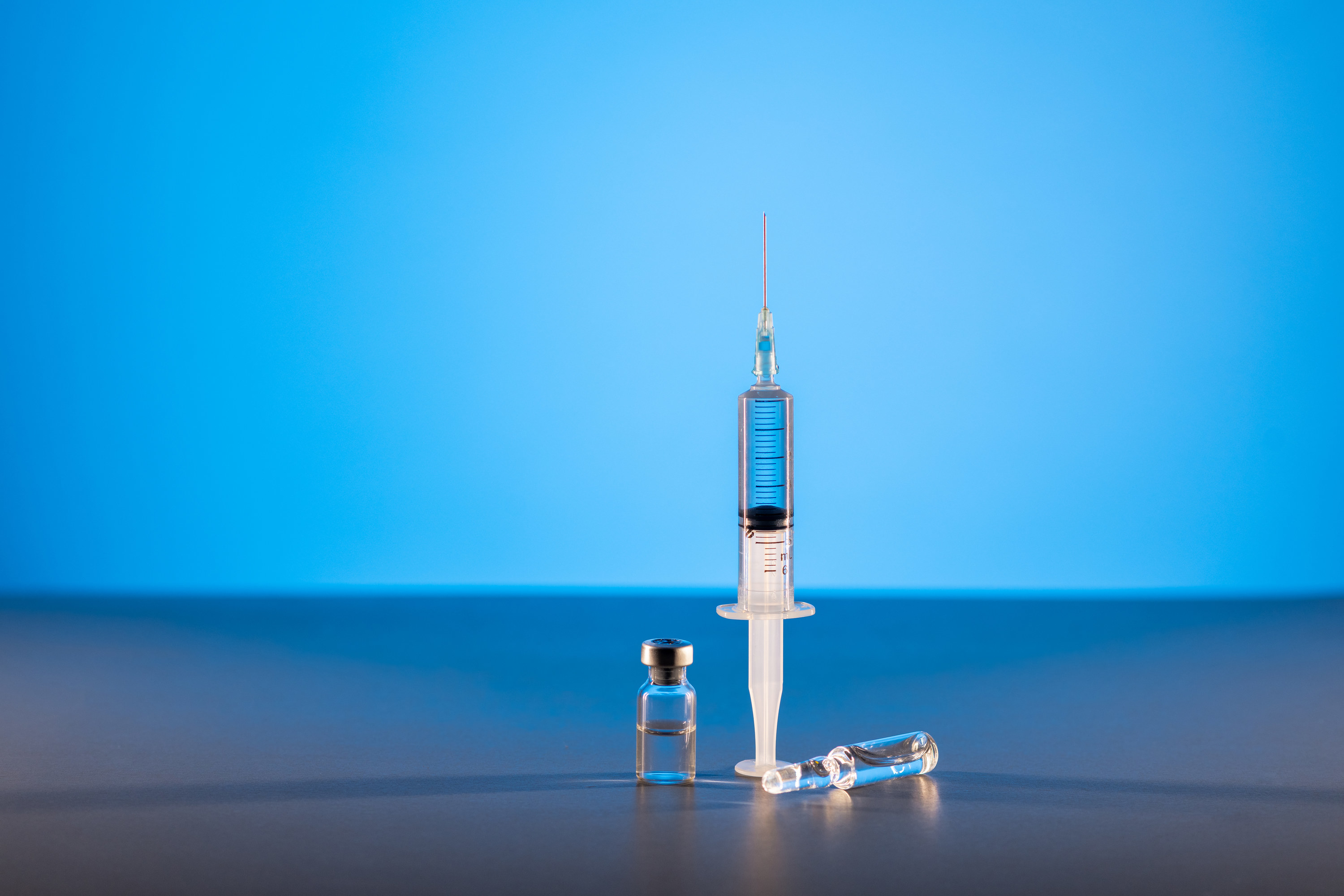 A syringe and small bottles of liquid medication