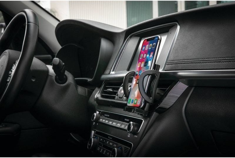 a phone attached to the black mount in a car