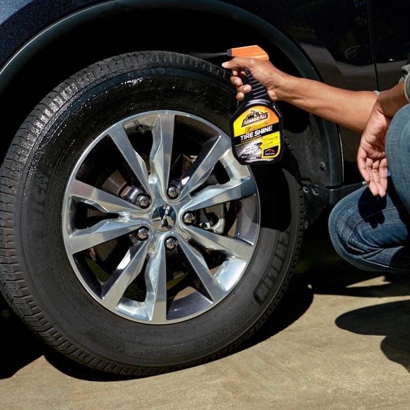a model using the black and yellow spray bottle on car tires