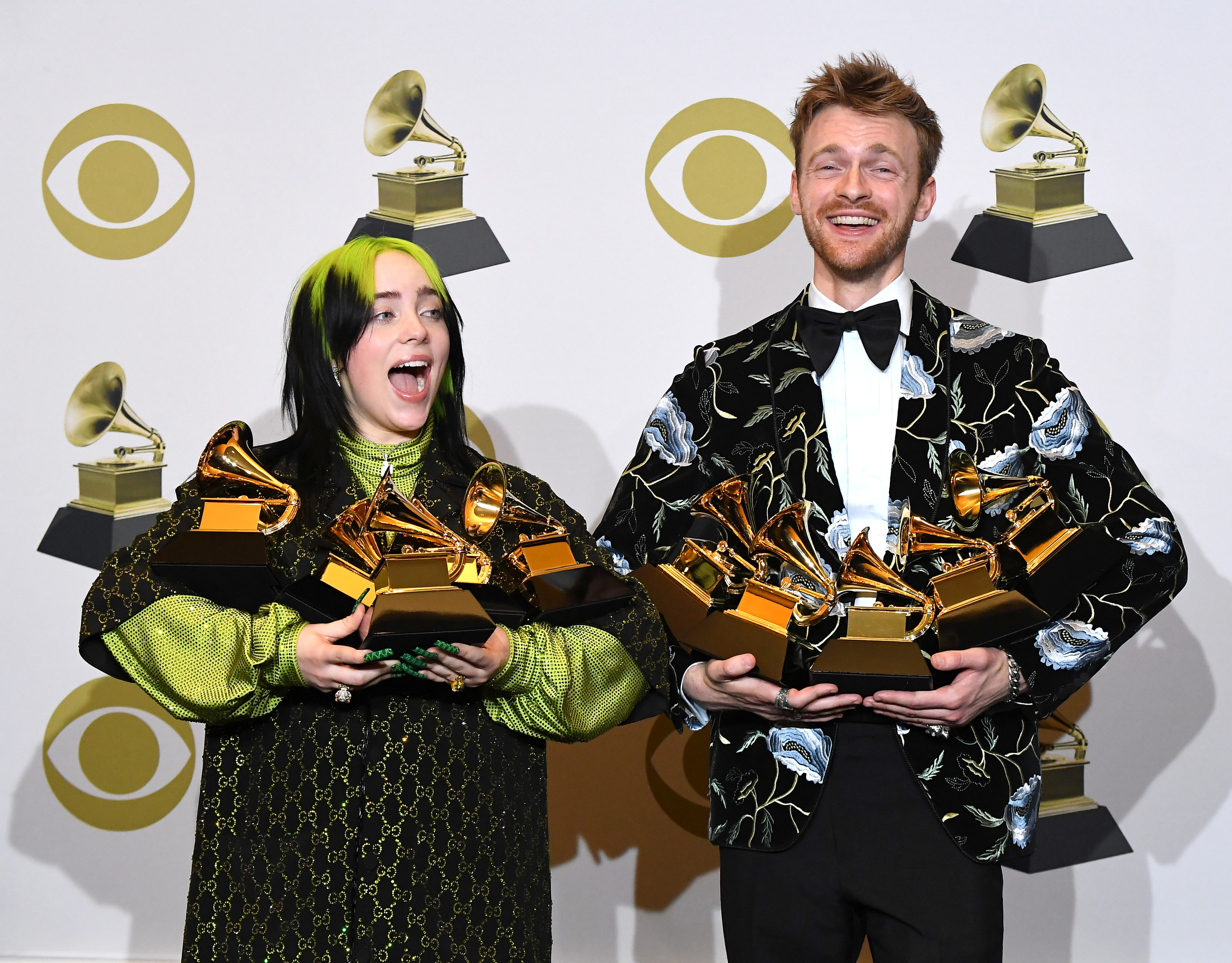 Billie and her brother and collaborator Finneas carrying their boatload of Grammys