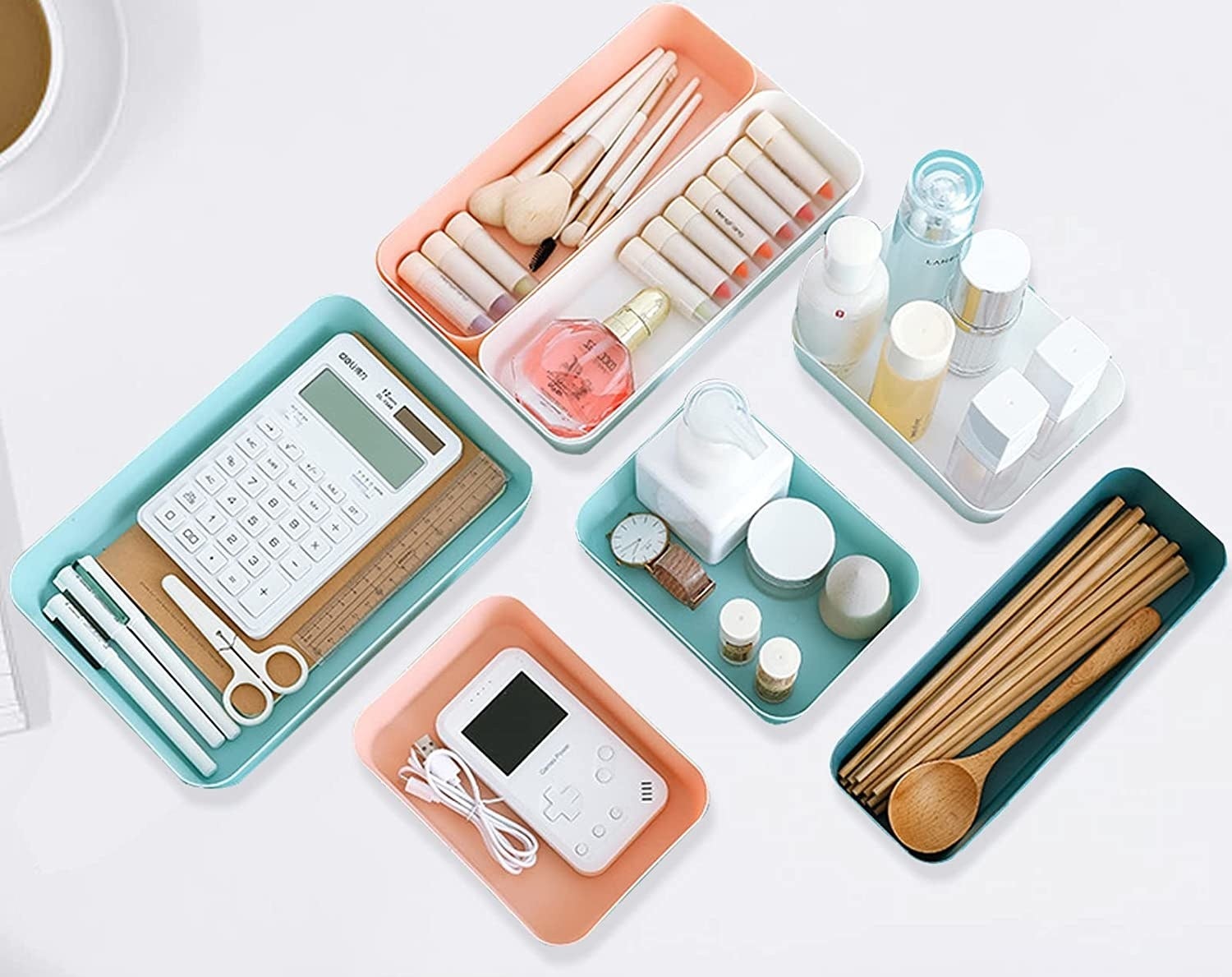 a set of colourful plastic drawer organizers filled with makeup, office supplies, and kitchen utensils