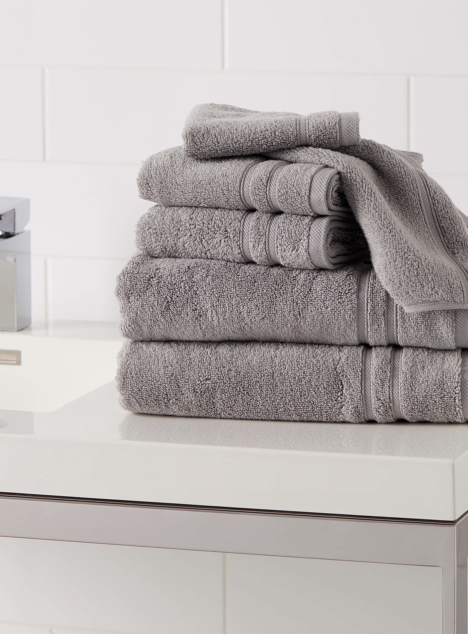 A set of folded towels sitting on a counter in a bathroom