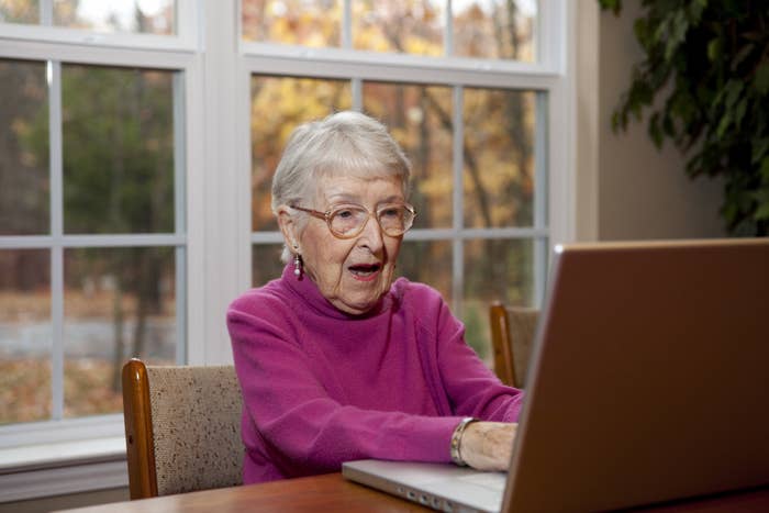 An older lady surprised by what she&#x27;s looking at on a computer