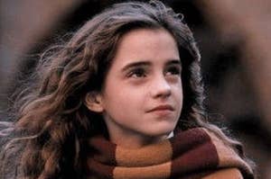 hermione granger wears a scarf, looks to the sky with brows slightly raise, mouth relaxed