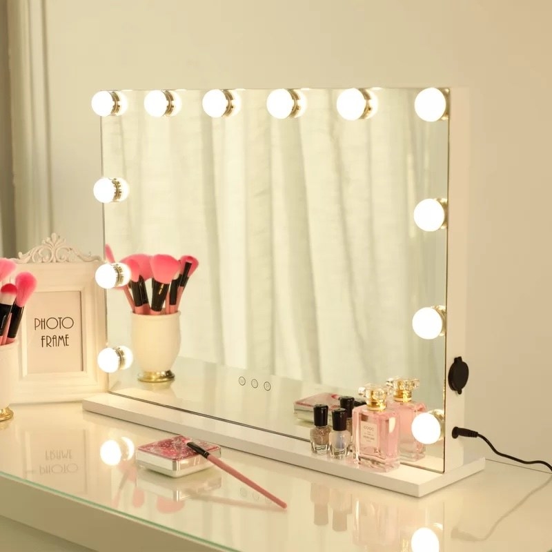 The makeup mirror with various makeup items around it