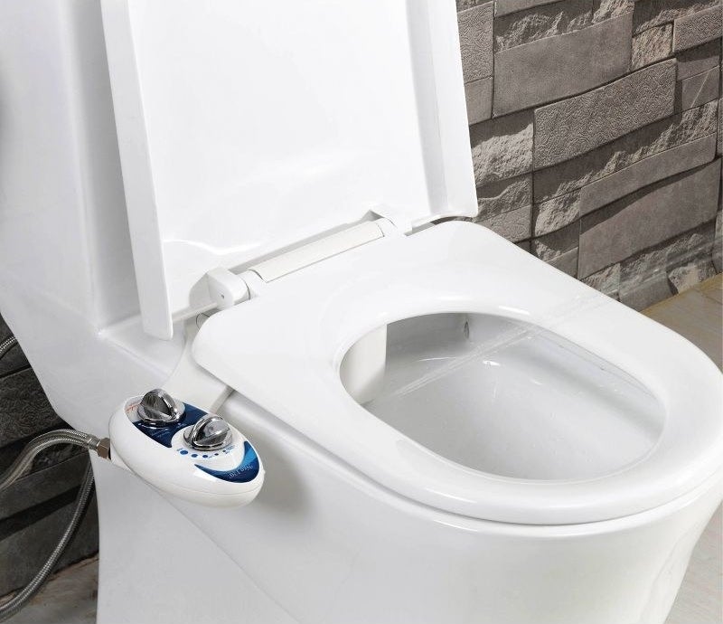 blue and white bidet attachment with silver knobs installed on a toilet