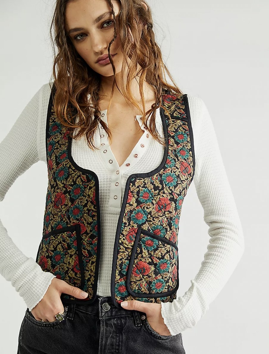 model wearing the quilted vest in a gold, blue, red and black design