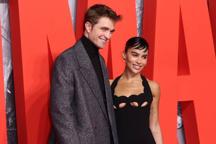 Robert and Zoë smiling as they pose for a photo together on the red carpet