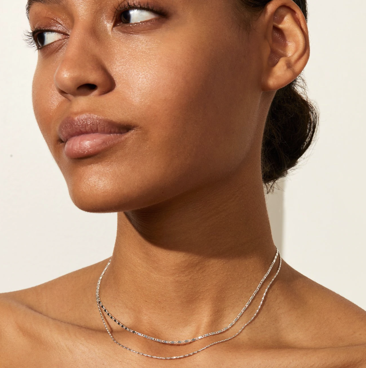 a person looking off camera while wearing the slim choker chain set around their neck