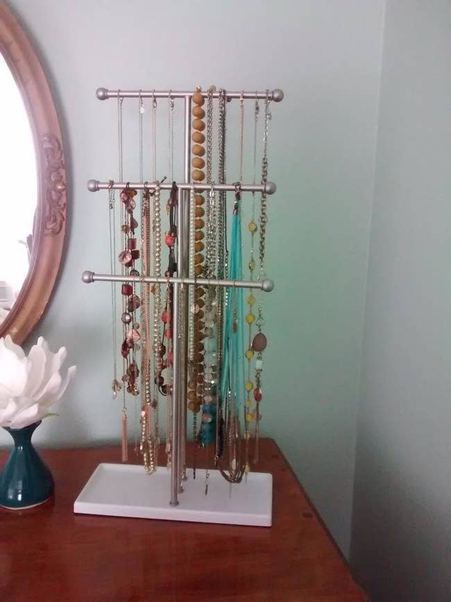 Small silver three tiered jewelry stand hold necklaces and rings 