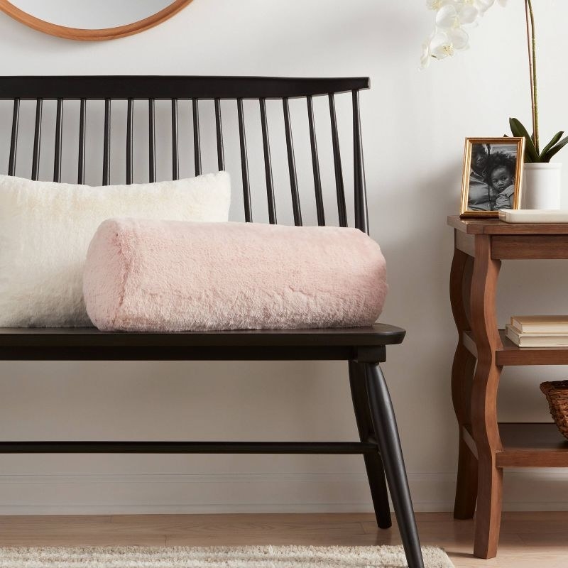 the pink pillow on a black bench