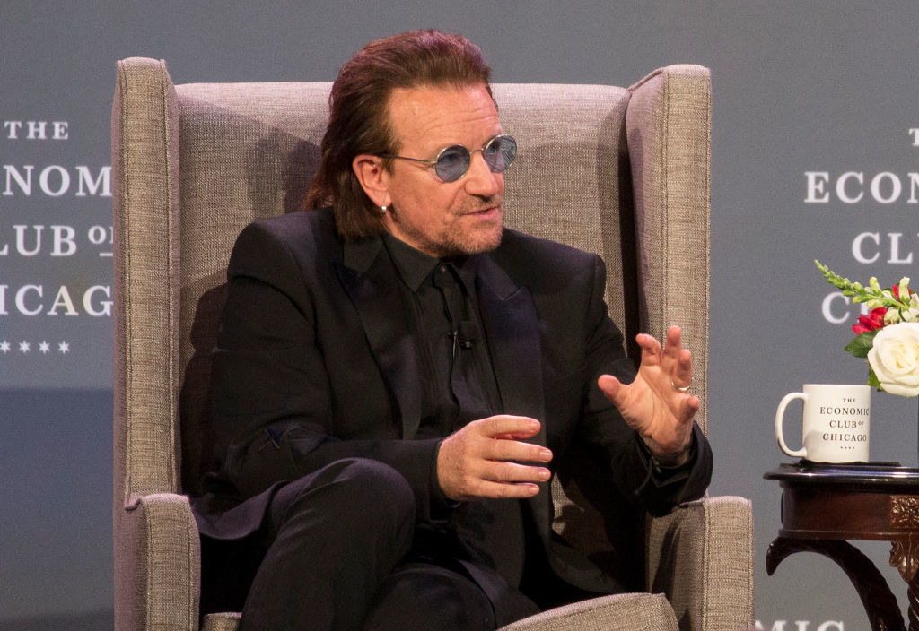 Bono speaking on stage at an event