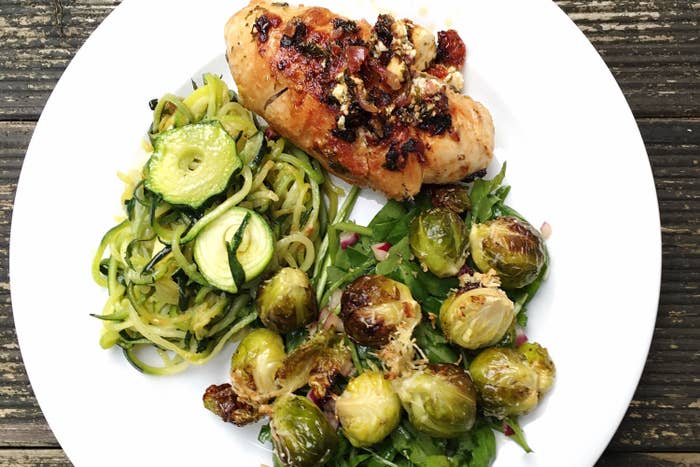 A plate of chicken, Brussels sprouts, and zucchini spirals.