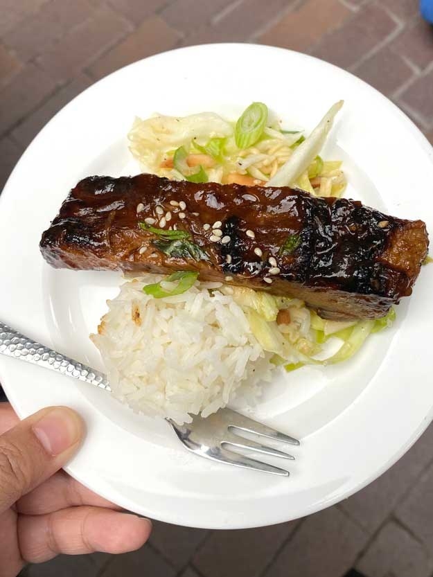 A close-up of plate with pork ribs on it and rice