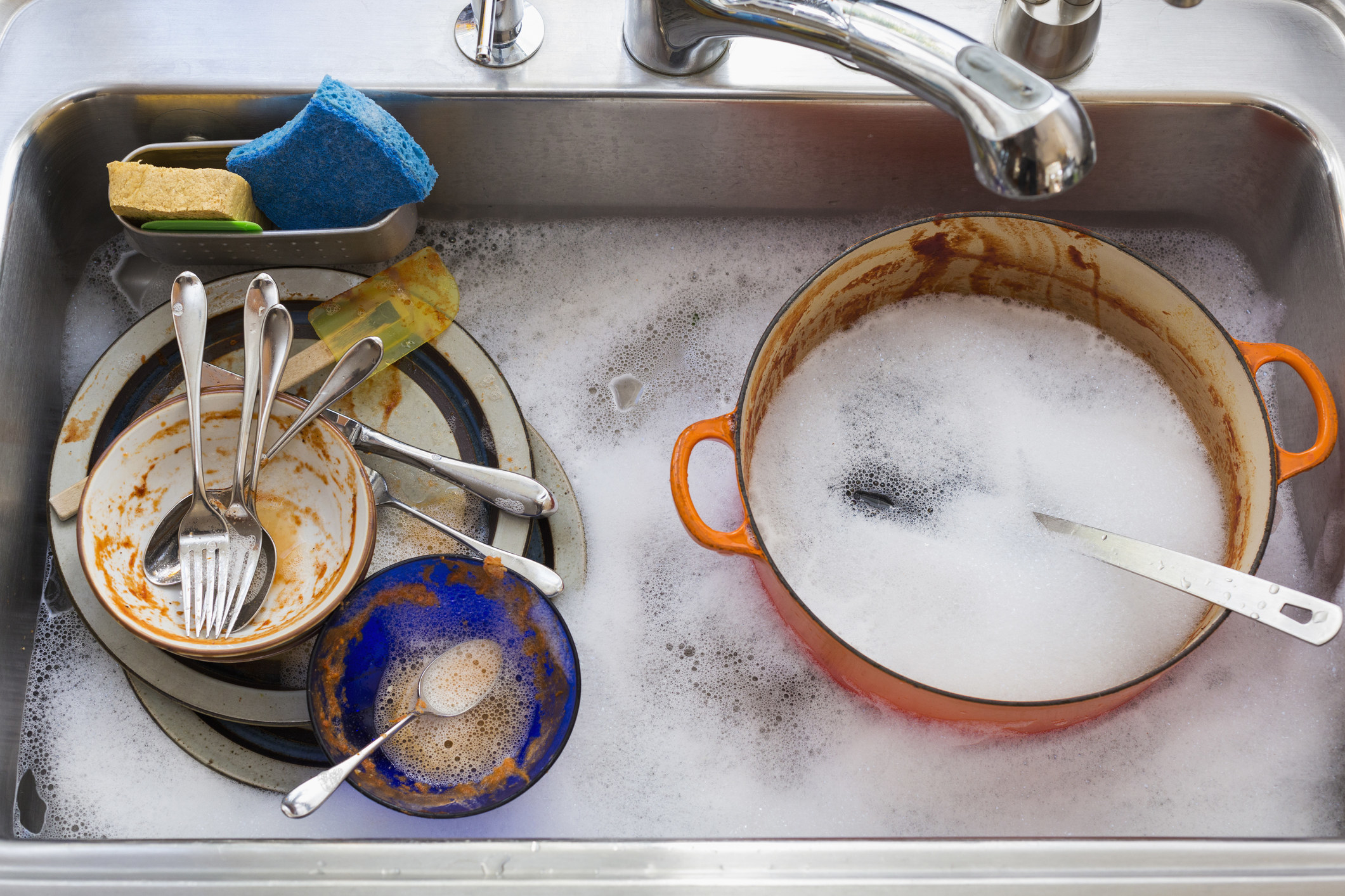 Kitchen sink full of dirty dishes.