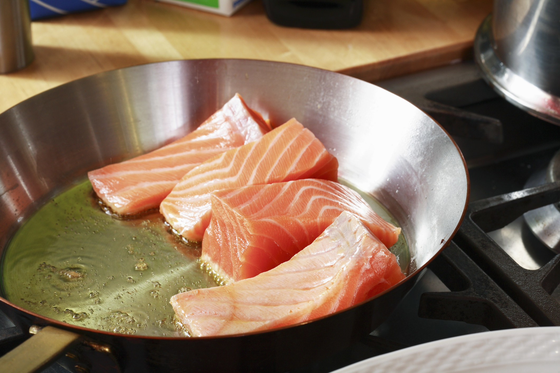 Fresh salmon frying in a pan.