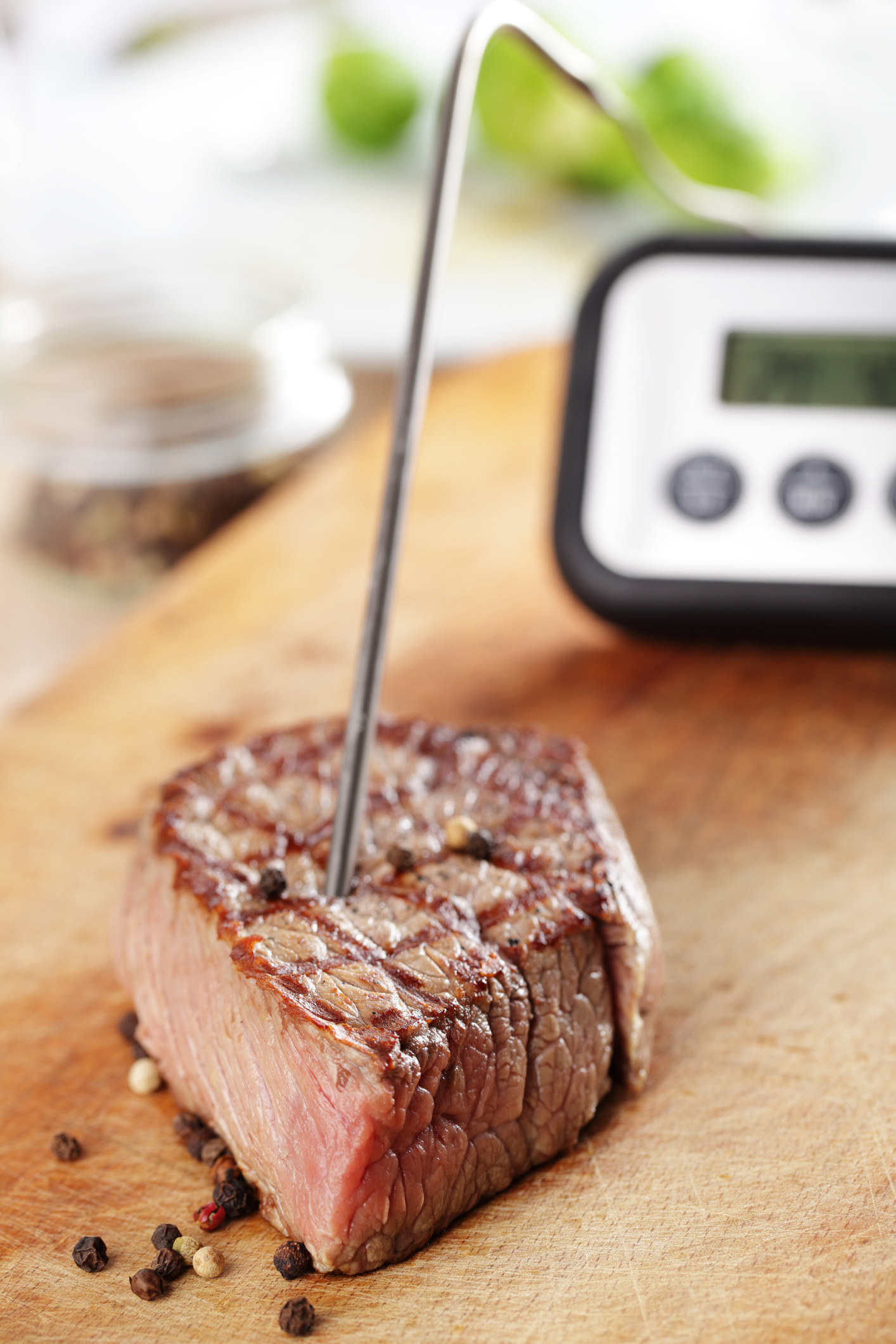 Checking the temperature of a piece of meat with a thermometer.