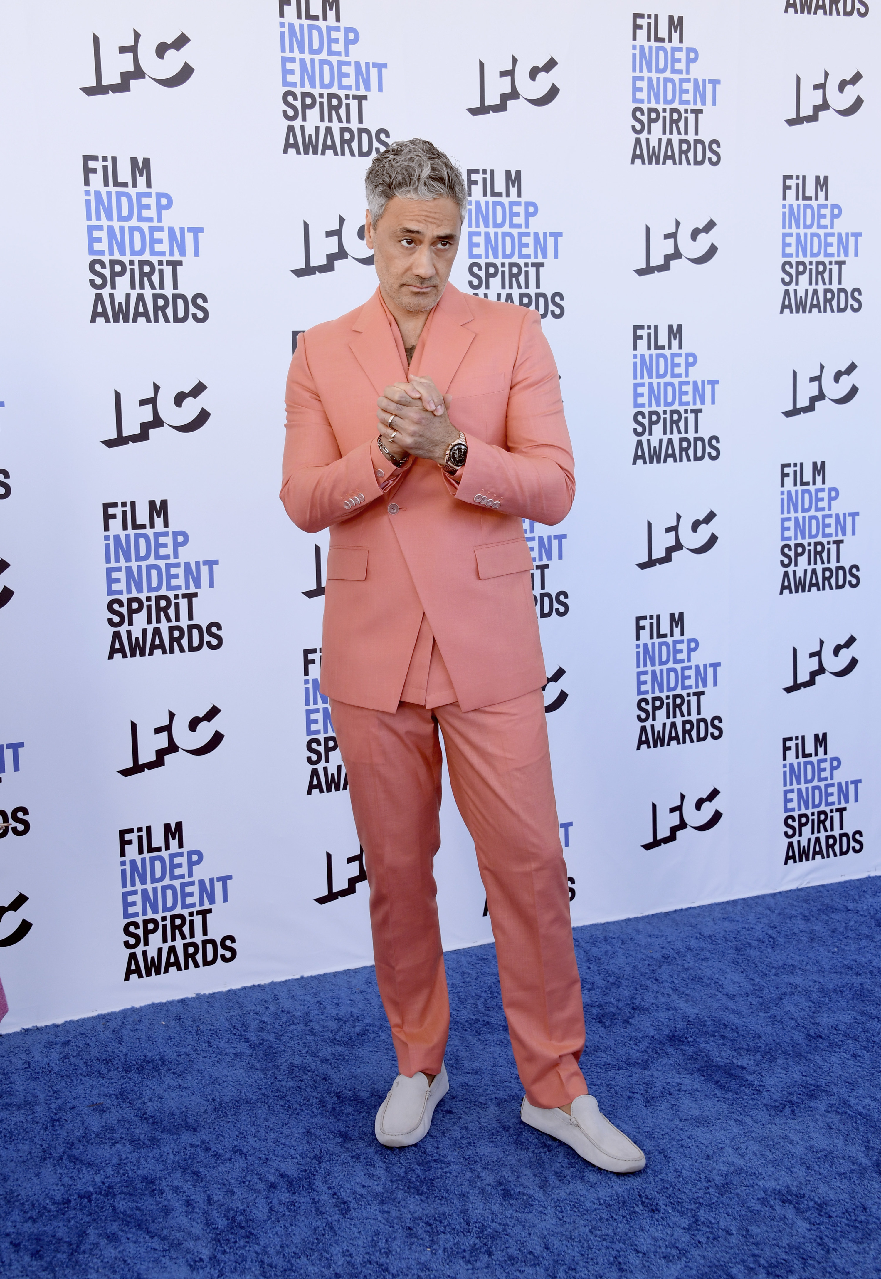 Taika wears a salmon colored suit