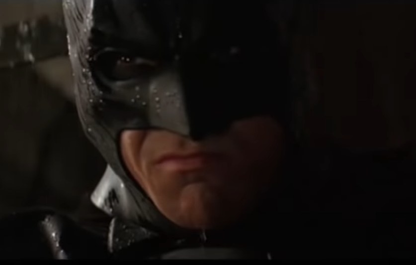 Christian Bales Batman interrogating someone with a fierce look on his face