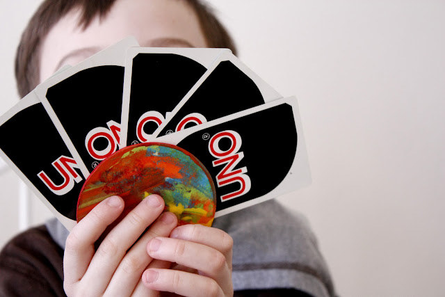 Blogger&#x27;s photo of their child using the card wheel to hold a few Uno cards